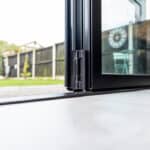 Thumbnail of http://Close-up%20of%20an%20open%20glass%20patio%20door%20with%20a%20view%20of%20a%20backyard%20garden,%20including%20a%20fence,%20grass,%20and%20outdoor%20furniture.