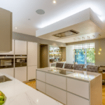 Thumbnail of http://Modern%20kitchen%20with%20an%20island,%20marble%20countertops,%20built-in%20ovens,%20and%20a%20bowl%20of%20fruit.%20There's%20a%20dining%20area%20with%20a%20table%20and%20tufted%20chairs%20near%20a%20large%20window.