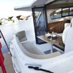 Thumbnail of http://View%20of%20a%20yacht's%20deck%20featuring%20a%20seating%20area%20with%20a%20table%20set%20for%20drinks,%20and%20a%20British%20flag%20at%20the%20stern,%20perfectly%20capturing%20the%20essence%20of%20leisurely%20boat%20life.