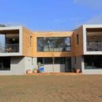 Thumbnail of http://This%20modern%20two-story%20house%20features%20sf75%20bifold%20doors,%20large%20windows,%20and%20wooden%20exterior%20sections%20with%20balconies.%20The%20front%20yard%20is%20bare%20soil,%20while%20potted%20plants%20adorn%20the%20entrance,%20adding%20a%20touch%20of%20greenery.