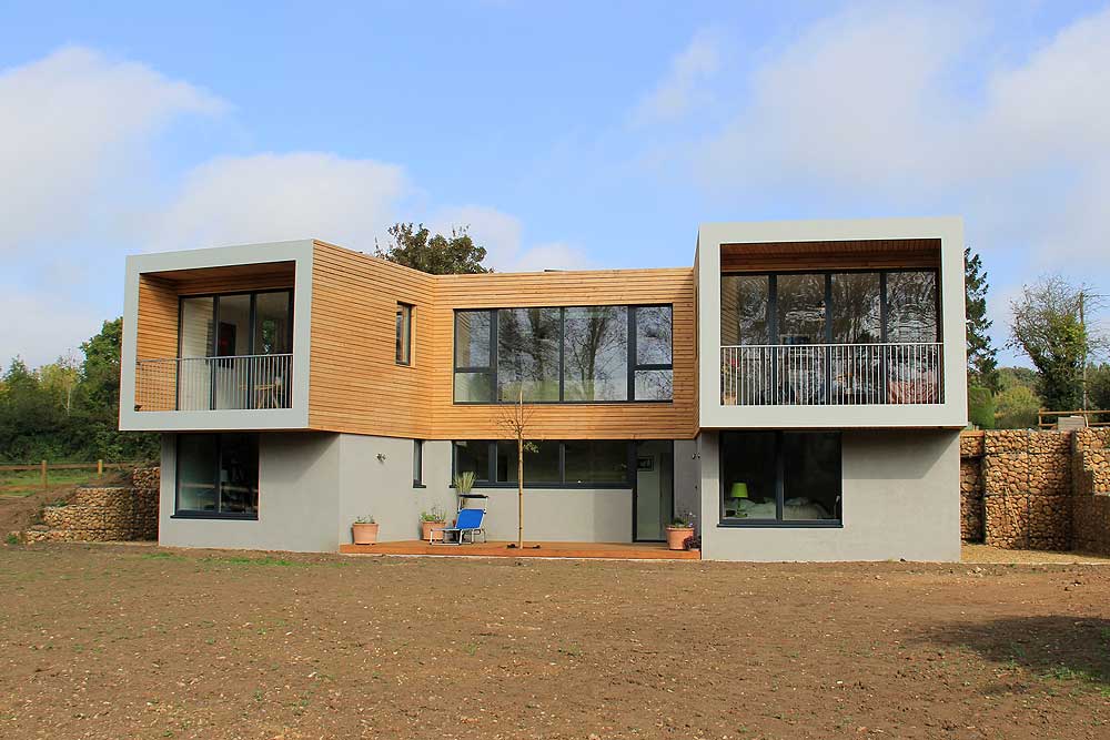 This modern two-story house features sf75 bifold doors that open to expansive balconies on both sides, enhancing the rural charm with large windows and elegant wood paneling.