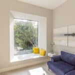 Thumbnail of http://Minimalist%20room%20with%20large%20window,%20two%20yellow%20cushions,%20blue%20couch,%20white%20side%20table%20with%20a%20lamp,%20and%20serene%20wall%20art.%20Sunlight%20filters%20through%20the%20window,%20illuminating%20the%20space.