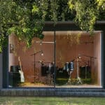Thumbnail of http://A%20modern%20music%20studio%20with%20glass%20walls,%20containing%20a%20drum%20set,%20electric%20guitar,%20microphone%20stands,%20and%20various%20audio%20equipment,%20surrounded%20by%20lush%20greenery.