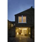 Thumbnail of http://Exterior%20view%20of%20a%20two-story%20brick%20house%20at%20dusk,%20with%20illuminated%20interiors%20visible%20through%20large%20glass%20doors%20on%20the%20ground%20floor.