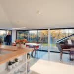 Thumbnail of http://Spacious%20modern%20room%20with%20large%20windows,%20reminiscent%20of%20a%20Grand%20Designs%20masterpiece,%20featuring%20a%20grand%20piano%20and%20a%20kitchen%20island%20adorned%20with%20plants,%20while%20a%20group%20of%20people%20gathers%20near%20the%20entrance.