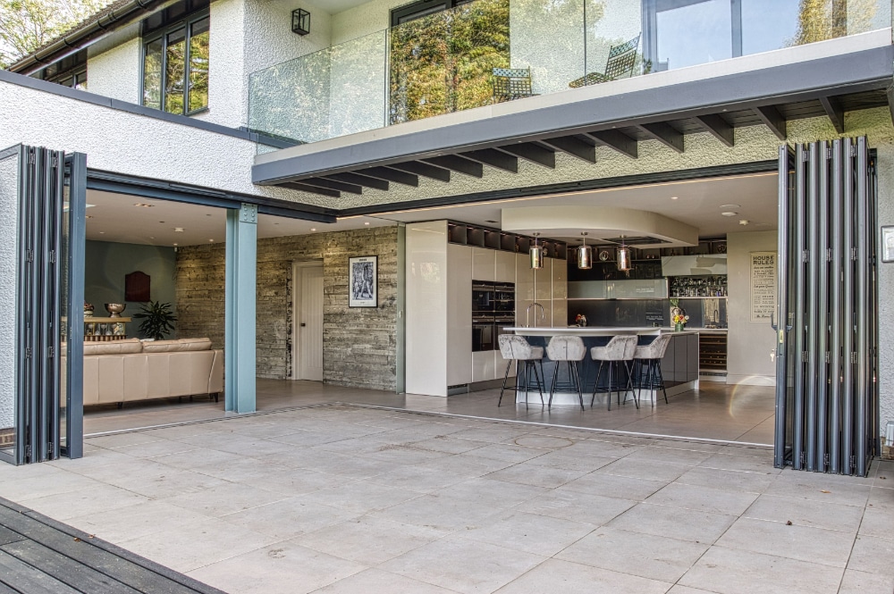 Modern open-plan kitchen and living area with sliding glass doors to a spacious patio.