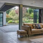 Thumbnail of http://Spacious%20living%20room%20with%20a%20tan%20leather%20sofa,%20open%20sliding%20doors,%20and%20a%20view%20of%20a%20garden.%20Modern%20decor%20with%20a%20large%20rug%20and%20decorative%20branches%20in%20a%20vase.