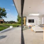 Thumbnail of http://Modern%20living%20area%20with%20sliding%20doors%20opens%20to%20reveal%20a%20landscaped%20garden%20featuring%20an%20extension%20by%20HBD%20Systems.%20Large%20windows%20frame%20a%20serene%20view%20of%20the%20tree%20and%20outbuilding.%20Inside,%20enjoy%20the%20comfort%20of%20a%20sofa,%20dining%20table,%20and%20wall-mounted%20TV.