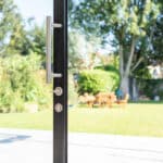 Thumbnail of http://Sliding%20doors%20from%20HBD%20Systems%20open%20to%20a%20sunny%20backyard%20with%20a%20lush%20green%20lawn,%20trees,%20and%20inviting%20patio%20furniture.