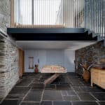 Thumbnail of http://Modern%20room%20with%20stone%20walls%20and%20floor,%20featuring%20a%20pool%20table%20in%20the%20center.%20Wooden%20furniture%20is%20placed%20on%20the%20right,%20and%20metal%20stairs%20lead%20to%20an%20upper%20level.