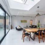 Thumbnail of http://Modern%20dining%20room%20with%20a%20wooden%20table,%20six%20chairs,%20a%20black%20couch,%20and%20a%20pendant%20light.%20Large%20sliding%20glass%20doors%20open%20to%20a%20patio.%20Light%20decor%20with%20a%20painting%20on%20the%20wall.