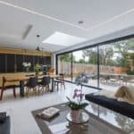 Thumbnail of http://Modern%20open-plan%20kitchen%20and%20dining%20area%20with%20sleek%20furnishings,%20large%20glass%20sliding%20doors,%20view%20of%20a%20patio%20with%20outdoor%20seating,%20and%20a%20skylight.