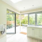 Thumbnail of http://Bright%20kitchen%20with%20cream%20cabinets%20and%20light%20wood%20flooring.%20Glass%20doors%20open%20to%20a%20patio%20with%20outdoor%20furniture%20and%20greenery.