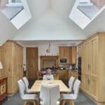 Thumbnail of http://Spacious%20kitchen%20with%20high%20ceiling%20and%20skylights,%20featuring%20wooden%20cabinets,%20a%20dining%20table%20with%20six%20chairs,%20and%20modern%20appliances.