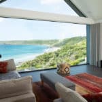 Thumbnail of http://Myrio%20Cornish%20home%20featuring%20expansive%20glazed%20bifold%20doors%20framing%20panoramic%20views%20of%20Sennen%20Cove's%20turquoise%20waters,%20sandy%20beach,%20and%20verdant%20coastal%20cliffs.