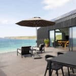 Thumbnail of http://Myrio%20Cornish%20home%20with%20Sunflex%20bifold%20doors%20opening%20onto%20coastal%20terrace%20overlooking%20Sennen%20Cove%20beach%20and%20sea.