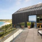 Thumbnail of http://Myrio%20Cornish%20coastal%20home%20with%20expansive%20bifold%20doors%20opening%20onto%20terrace%20overlooking%20Sennen%20Cove%20beach%20and%20turquoise%20waters.