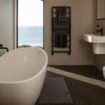 Thumbnail of http://Luxury%20bathroom%20at%20Myrio,%20Sennen%20Cove%20Cornwall,%20featuring%20freestanding%20bath%20with%20sea%20views%20through%20large%20glazed%20opening%20and%20contemporary%20white%20sanitaryware.